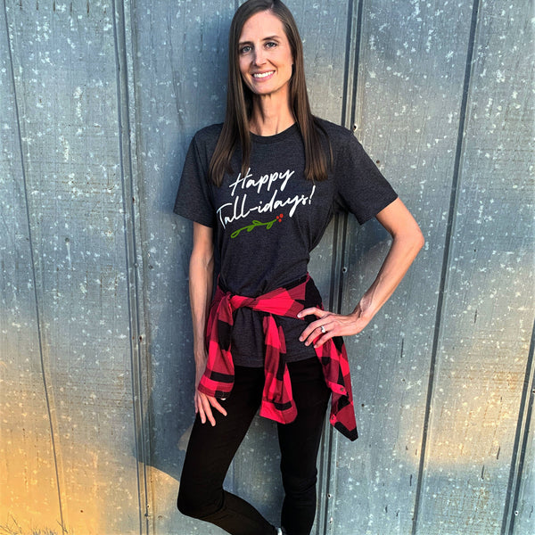 Tall woman wearing a Happy Tall-idays holiday t-shirt.