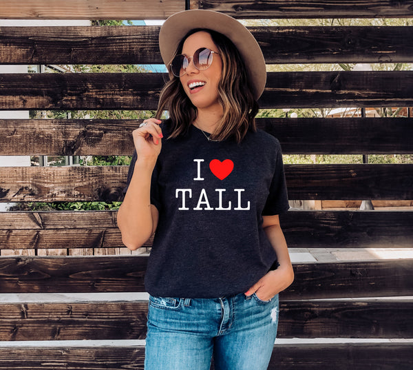 Model wearing an "I Heart Tall" t-shirt design.