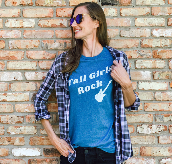 Tall woman wearing a trendy, distressed vintage graphic t-shirt with a Tall Girls Rock guitar design.