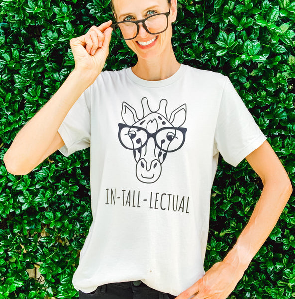 Tall woman wearing a giraffe t-shirt with the phrase "IN-TALL-LECTUAL".
