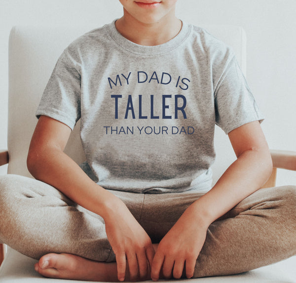 Youth boy wearing a "My Dad Is Taller Than Your Dad" children's tee-shirt.