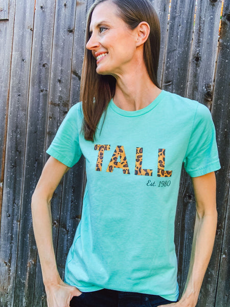 Tall woman wearing a "Tall Est." custom tee-shirt from Tall Reali-tees.Tall woman wearing a "Tall Est." custom tee-shirt from Tall Reali-tees.